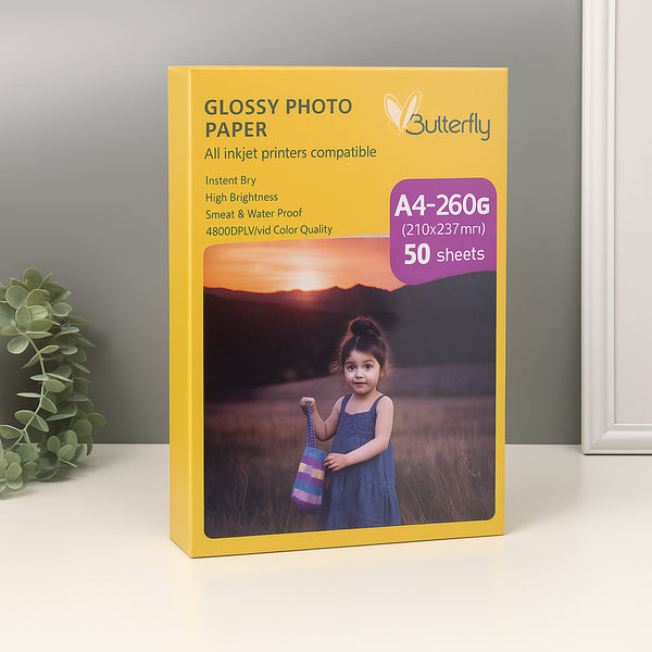 Butterfly Glossy Photo Paper packaging with a child holding a colorful knitted item on a white surface.
