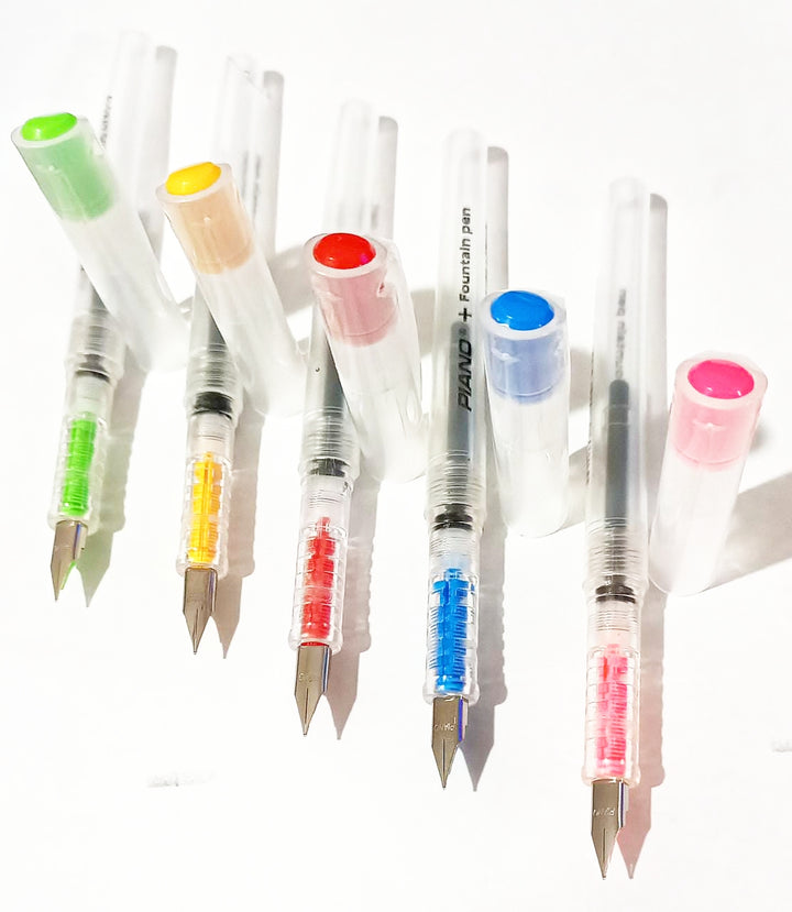 Set of fountain pens with colorful ink cartridges on a white background